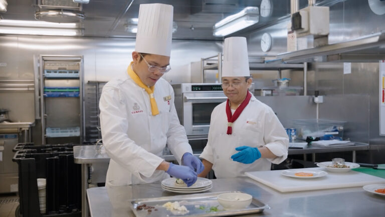 Two chefs in the galley on board a Cunard ship.
